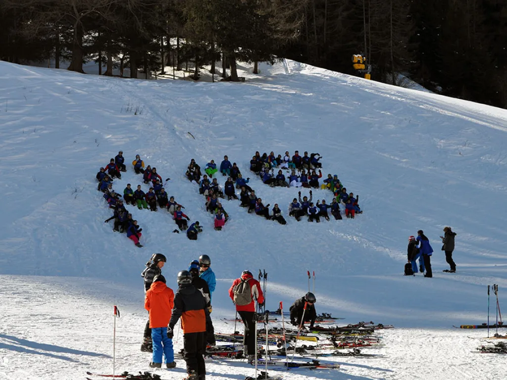 Große Gruppe formt im Schnee den Schriftzug ARS.